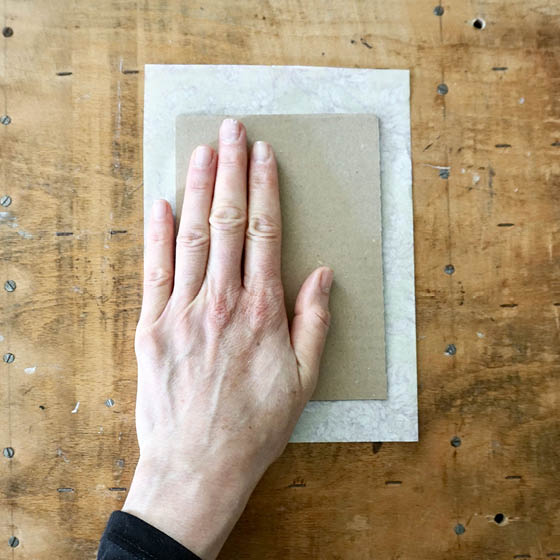 Pappe wird auf Papier geklebt