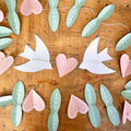 DIY Frühlingsgirlande: ausgeschnittene Blätter, Herzen und Vögel auf einer Schnur