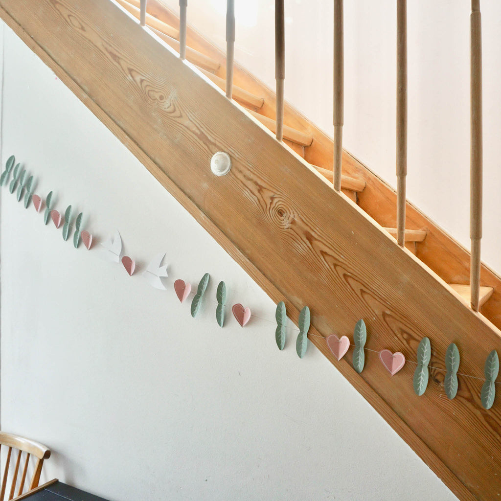 DIY Frühlingsgirlande: ausgeschnittene Blätter, Herzen und Vögel auf einer Schnur - Dekobeispiel: Girlande an Treppe