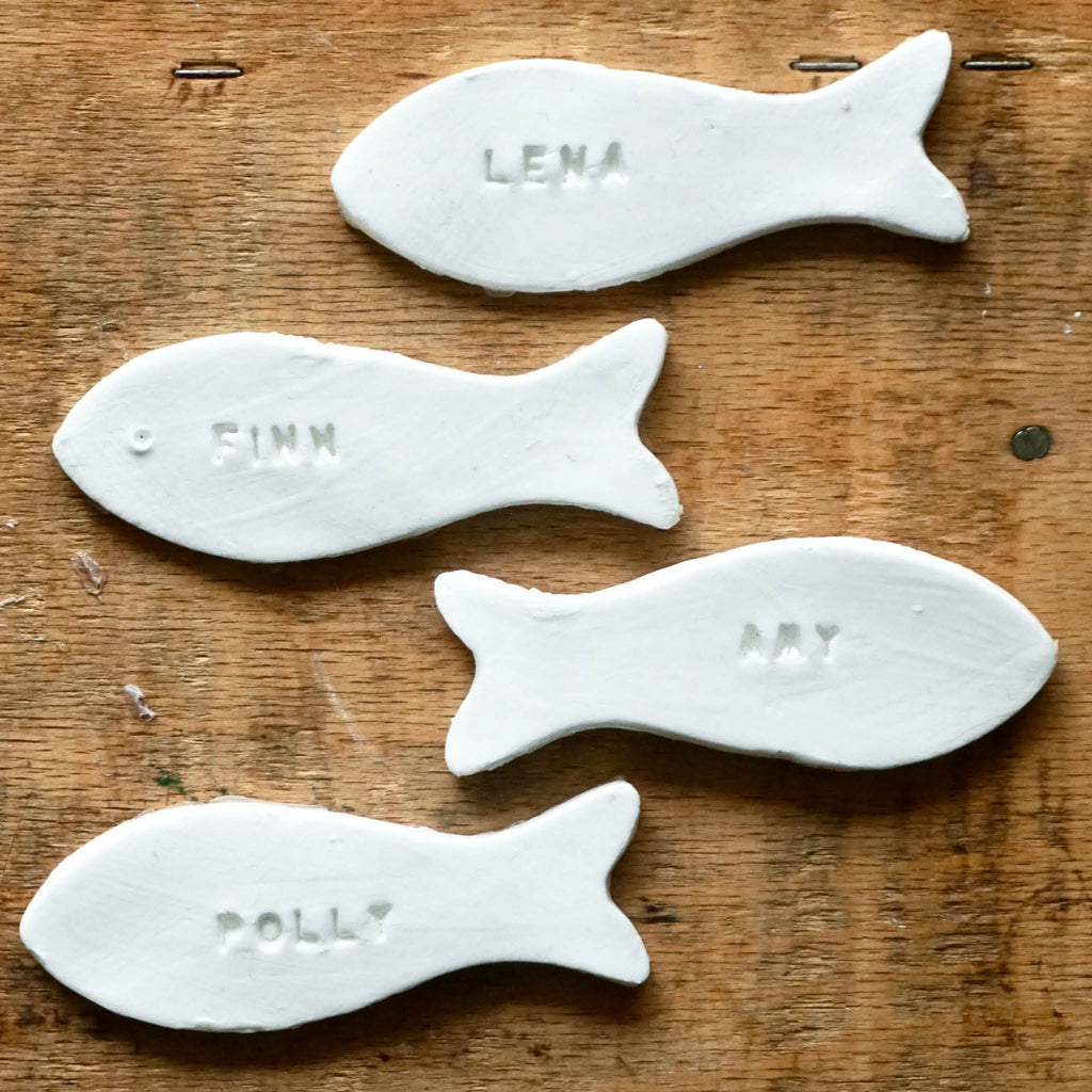 Platzkarten aus Modelliermasse in Fischform - 4 Beispiele: Weiße Fische mit eingestempelten Namen
