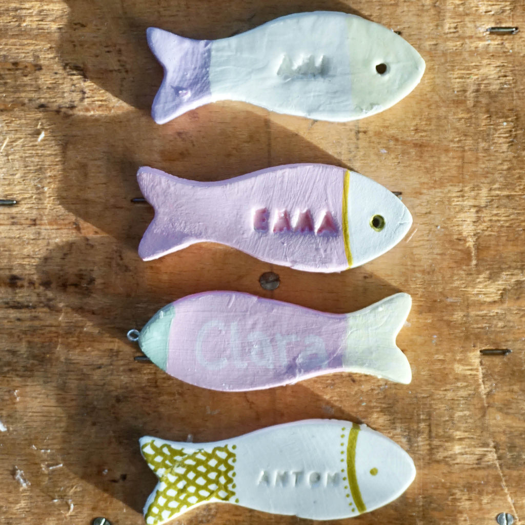 Platzkarten aus Modelliermasse in Fischform: Anwendungsbeispiel: Fische in Rosa und Gold bemalt